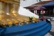 Thailand: A devotee places flowers at the foot of the giant standing Buddha, Wat Intharawihan, Bangkok